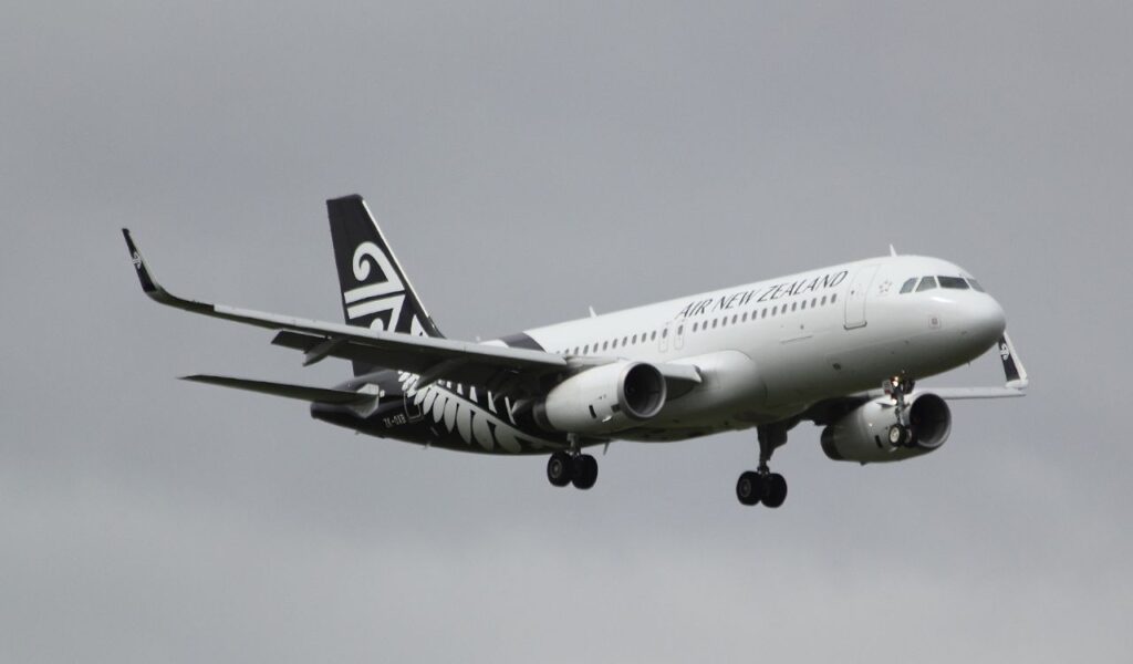 Air New Zealand plane in flight against a cloudy sky.